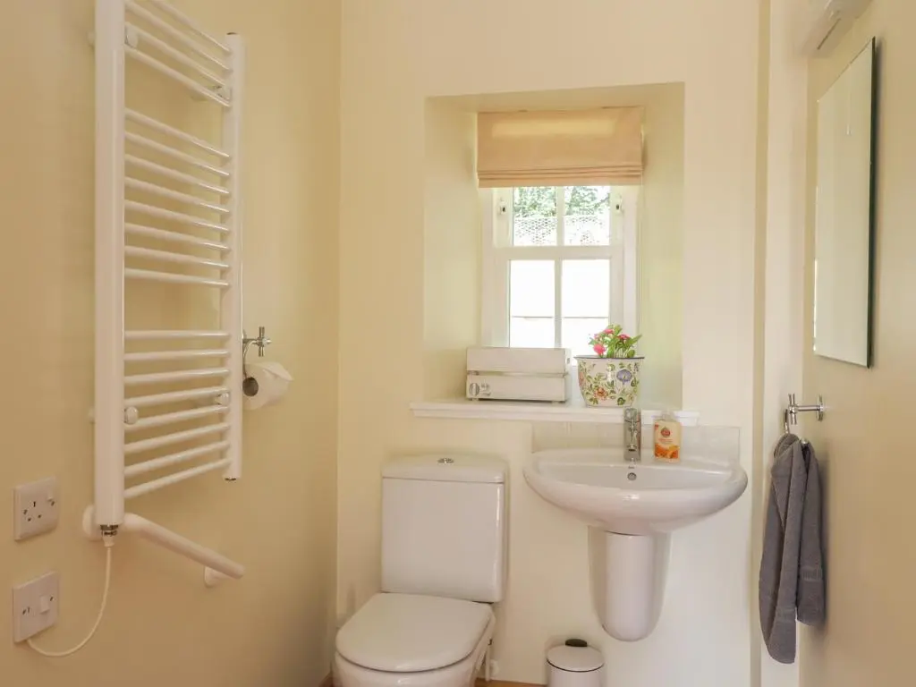 a bathroom with a toilet and a sink and a window at Drumhead Bothy in Banchory