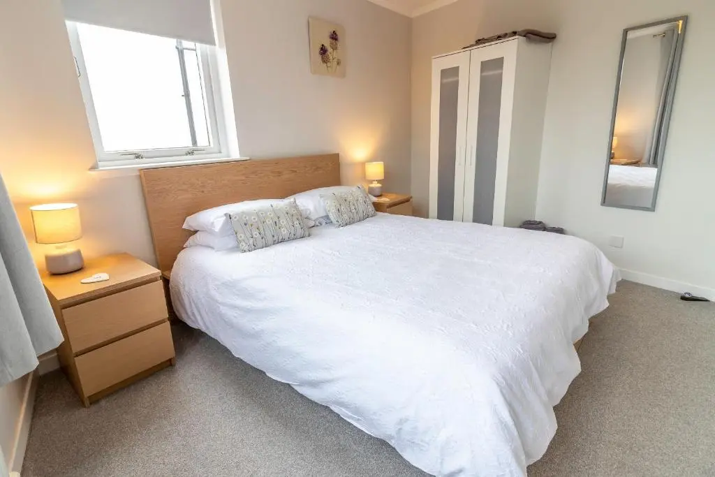 a bedroom with a large white bed and two lamps at Fishertown House in Nairn