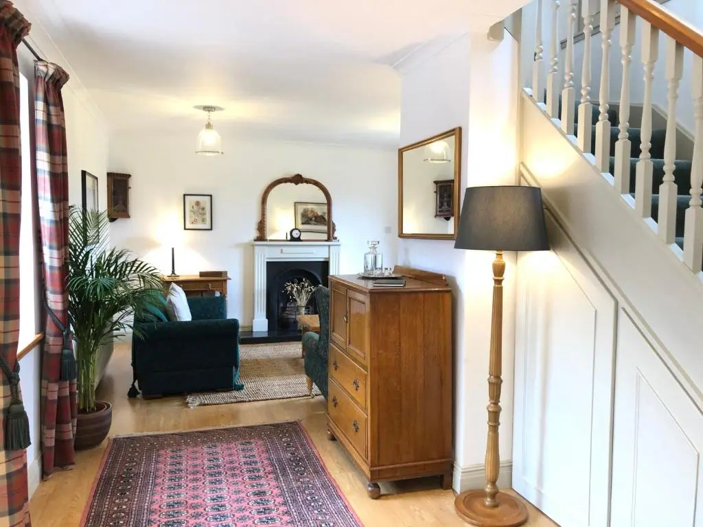 a living room with a staircase and a lamp at Glenmuir Cottage in Dornoch