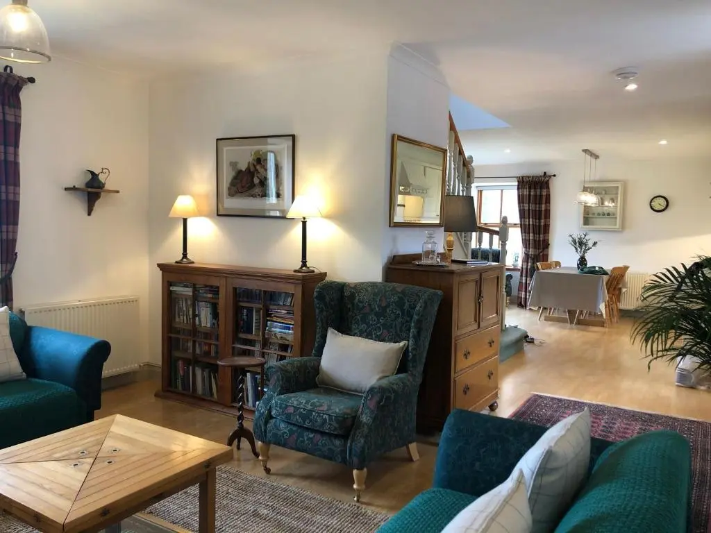 a living room with two chairs and a table at Glenmuir Cottage in Dornoch