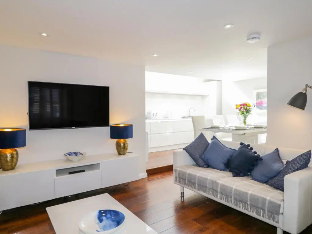 a living room with a couch and a tv at 36 Sandend Village in Banff