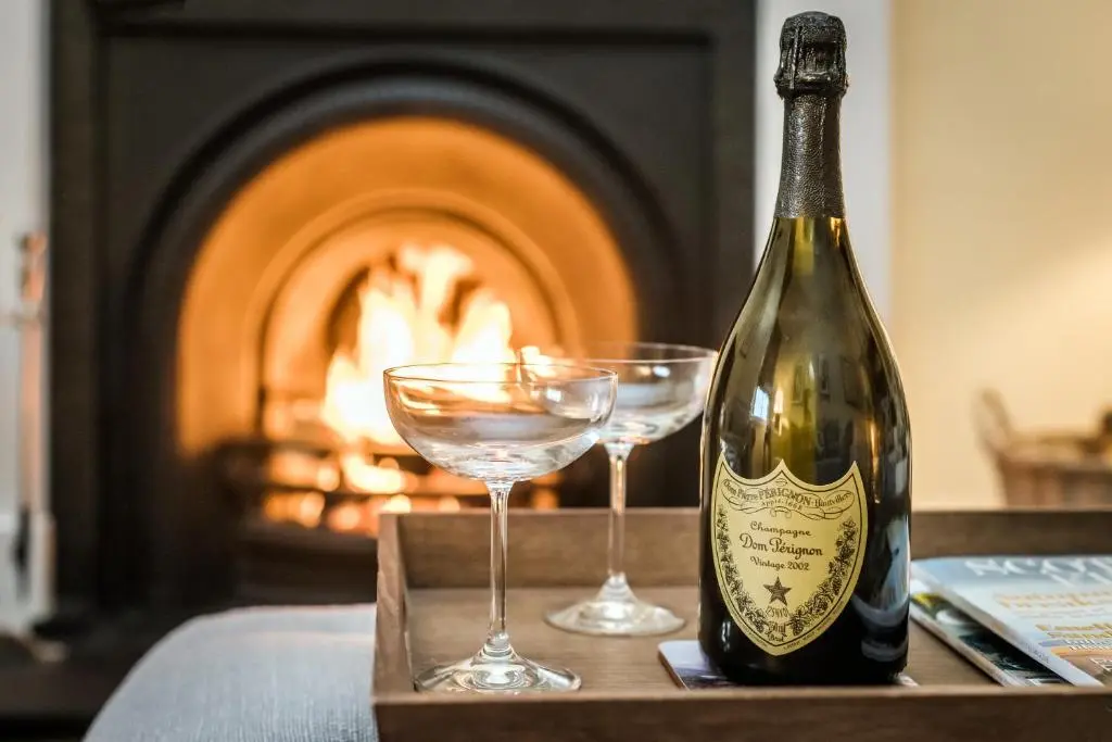 a bottle of champagne and two glasses on a table at The Old Manse, Loch Ness (highland-escape) in Inverness