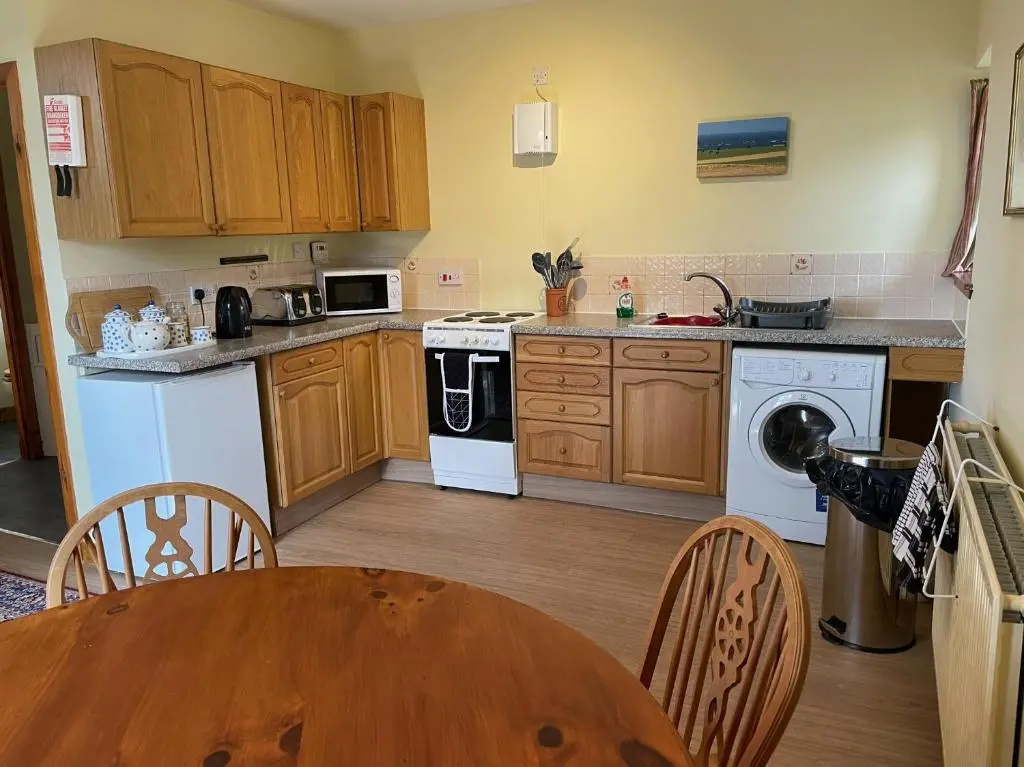 a kitchen with wooden cabinets and a wooden table with a tableablish at West Gorton in Grantown on Spey