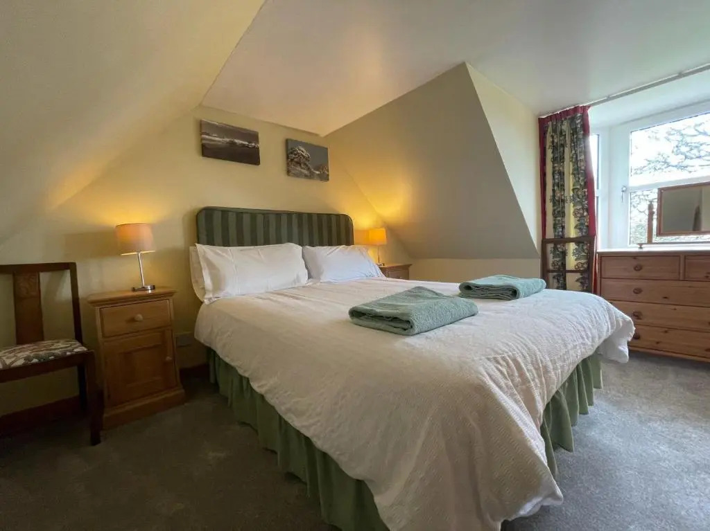 a bedroom with a bed with two towels on it at West Gorton in Grantown on Spey