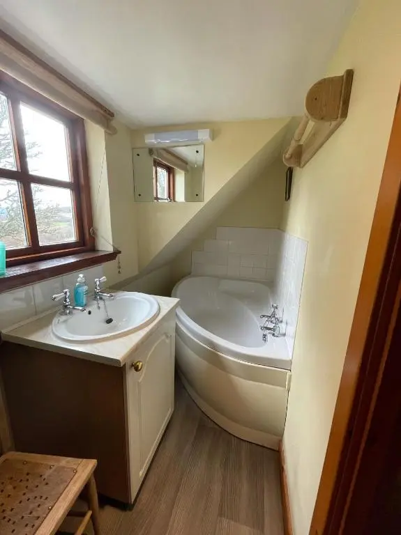 a bathroom with a bath tub and a sink at West Gorton in Grantown on Spey