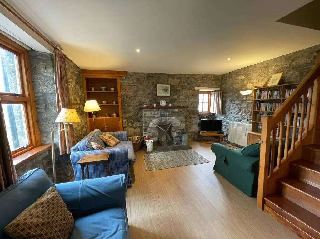 a living room with a couch and a fireplace at West Gorton in Grantown on Spey