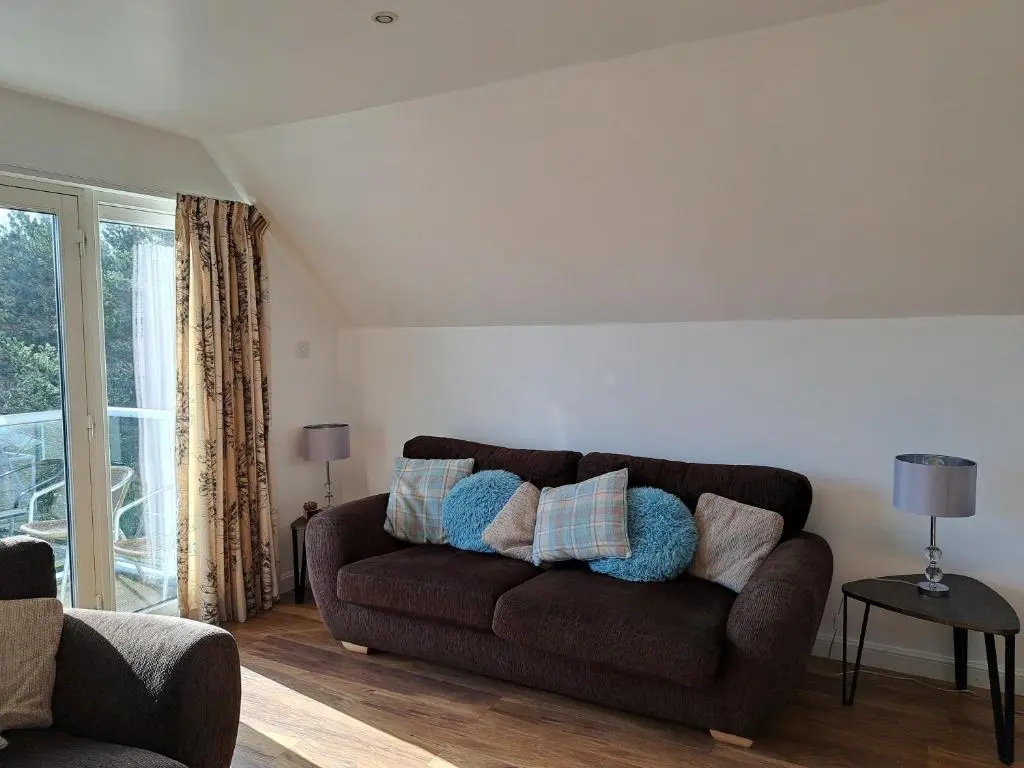 a living room with a brown couch with pillows on it at Inchmarlo Golf Resort, Banchory Villa 26 AS 00266F in Banchory