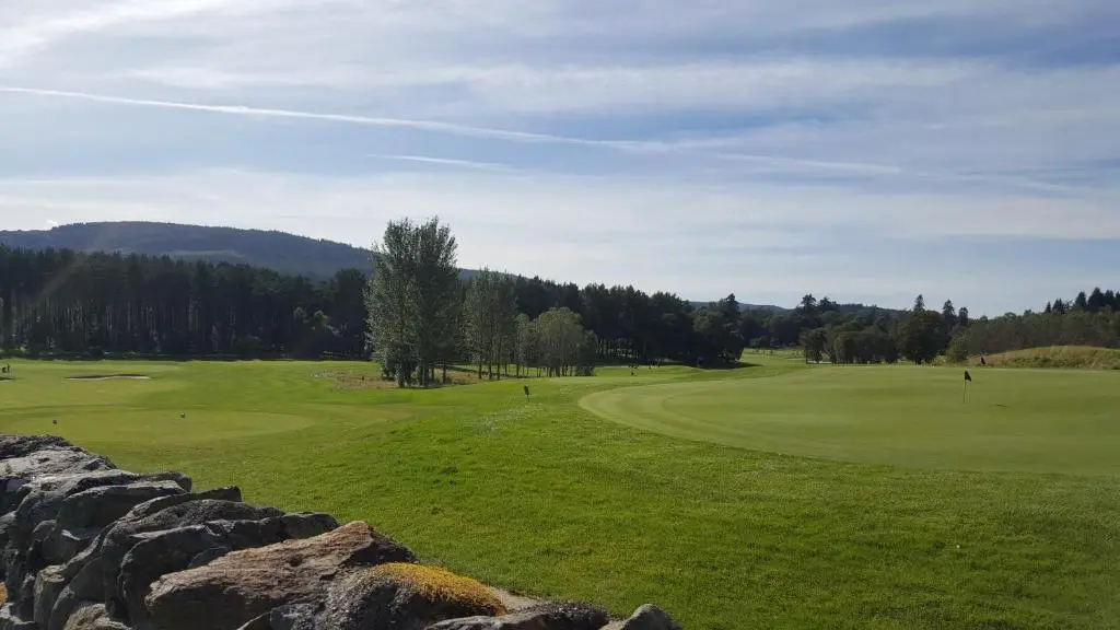 a view of a golf course with a stone wall at Inchmarlo Golf Resort, Banchory Villa 26 AS 00266F in Banchory