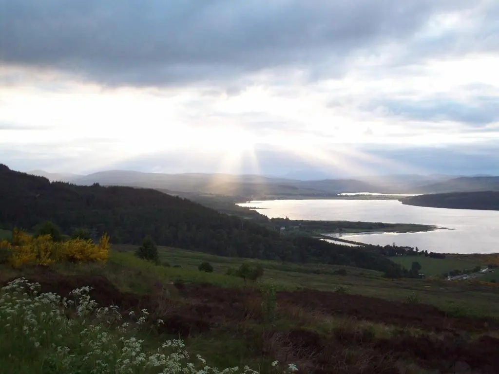 a view of a body of water with the sun shining at Lairg Highland Hotel in Lairg