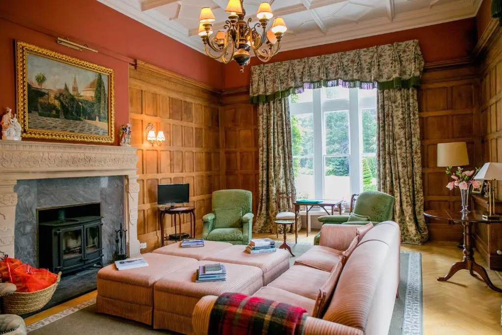 a living room with a couch and a fireplace at Scatwell House in Garve