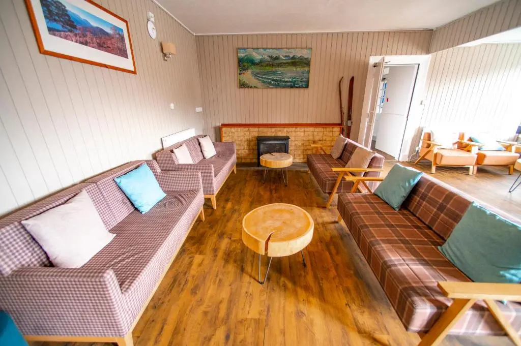 a living room with couches and a fireplace at Cairngorm Lodge Youth Hostel in Loch Morlich