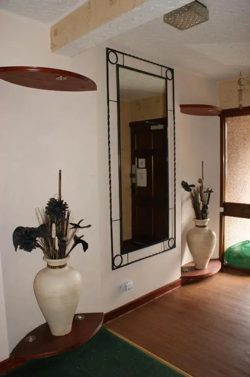 a mirror in a room with two vases with plants in it at Ardentorrie Guest House in Inverness