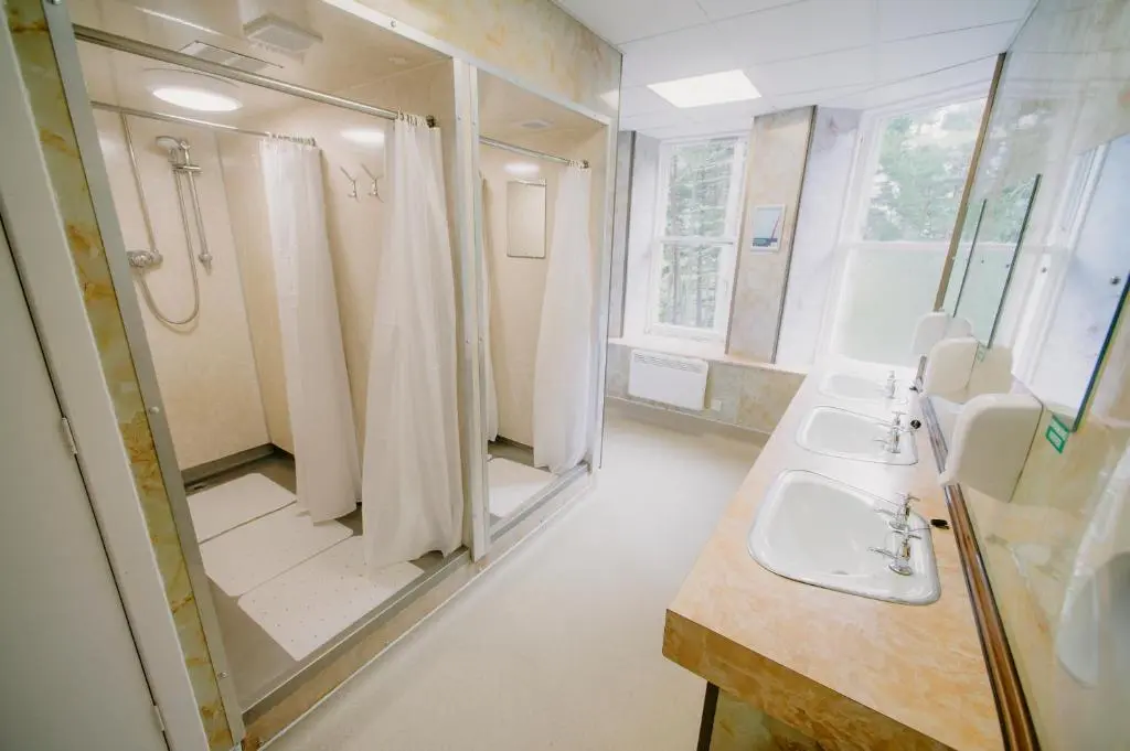 a bathroom with two sinks and a shower at Braemar Youth Hostel in Braemar