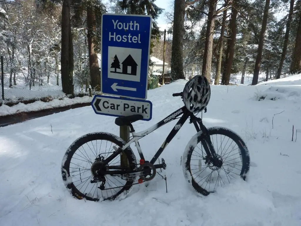 a bike parked next to a car park sign at Braemar Youth Hostel in Braemar