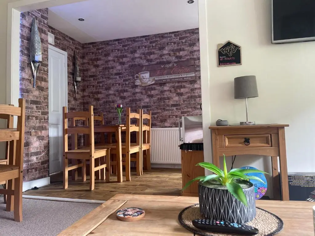 a living room with a table and chairs and a brick wall at Charleston Apartment One Bedroom sleeping 2 in Inverness
