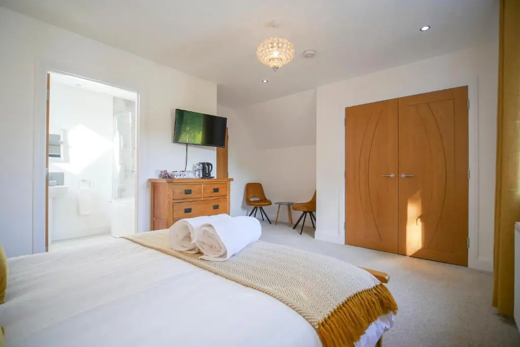 a bedroom with a bed with two towels on it at Pinewood Cottage Apartment & B&B Inverness in Inverness