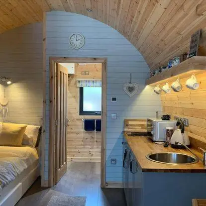 a kitchen with a sink and a bed in a room at Daviot Luxury Pods in Inverness