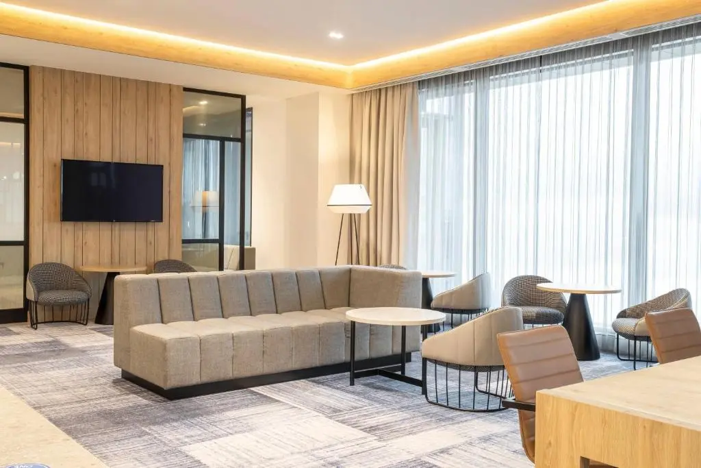 a hotel lobby with a couch and tables and chairs at Courtyard by Marriott Inverness Airport in Inverness