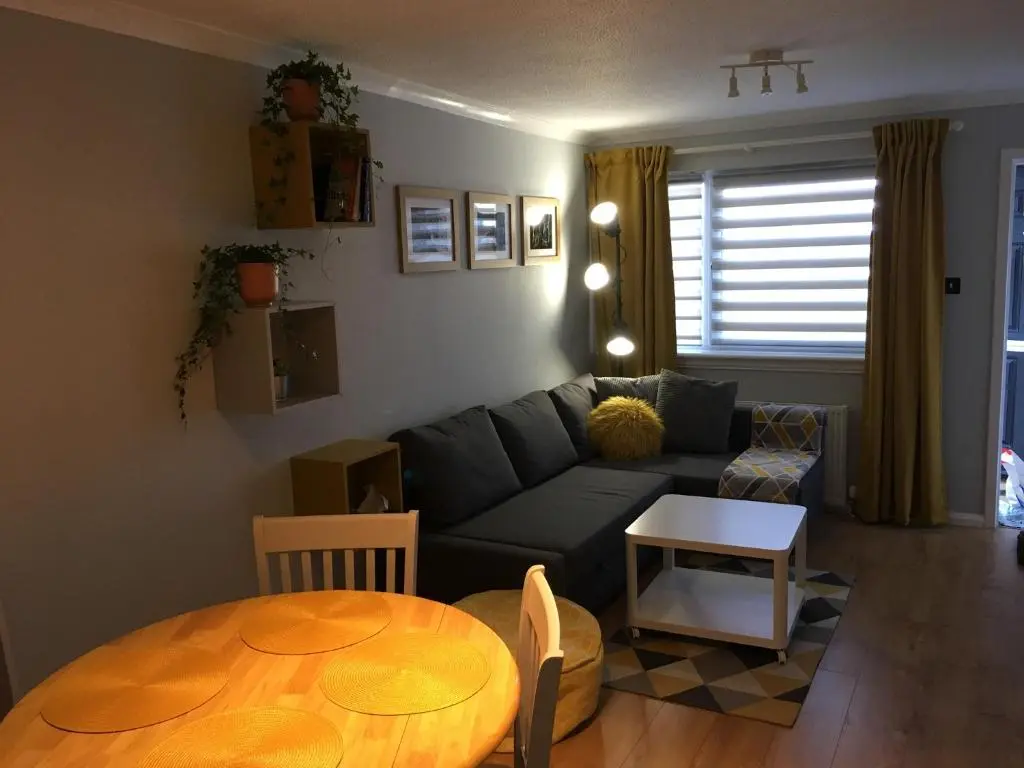 a living room with a couch and a table at Highfield apartment in Inverness