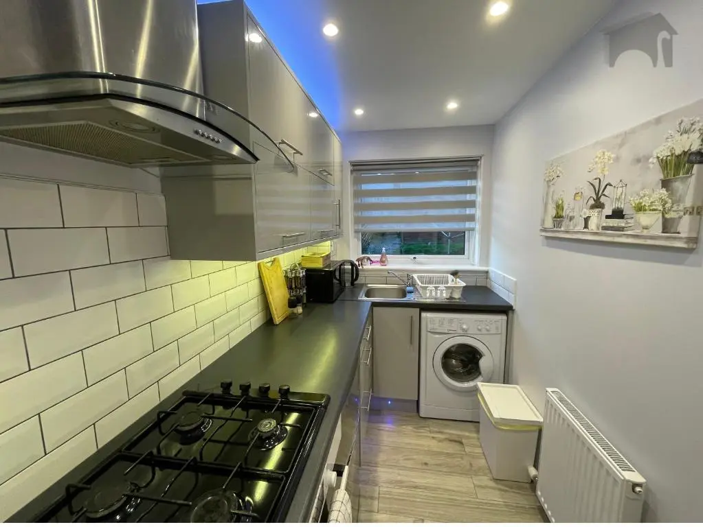 a kitchen with a stove and a washing machine at Highfield apartment in Inverness