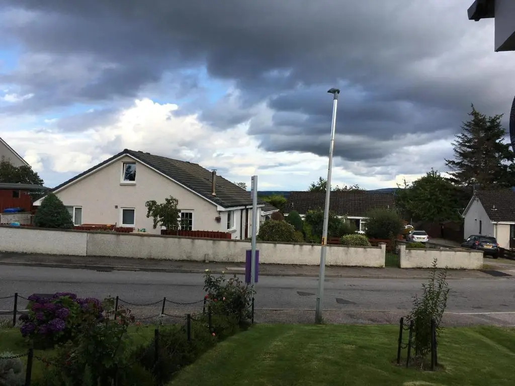 a white house on the side of a street at Highfield apartment in Inverness