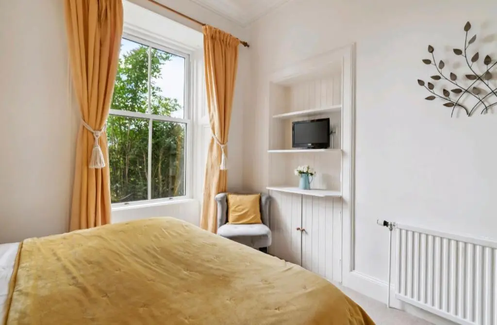 a bedroom with a bed and a window at Kinnaird Country House with Hot Tub in Pitlochry