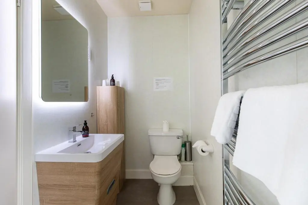 a bathroom with a sink and a toilet and a mirror at Kinnaird Country House with Hot Tub in Pitlochry