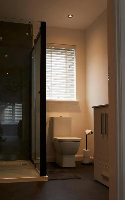 a bathroom with a toilet and a window at Shoreland Lodges - Holly Lodge in Fort Augustus