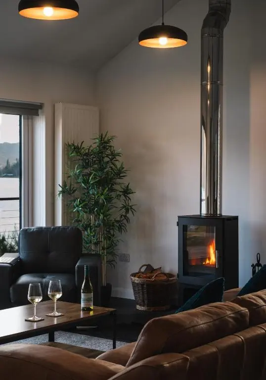 a living room with a couch and a fireplace at Shoreland Lodges - Cherry Lodge in Fort Augustus