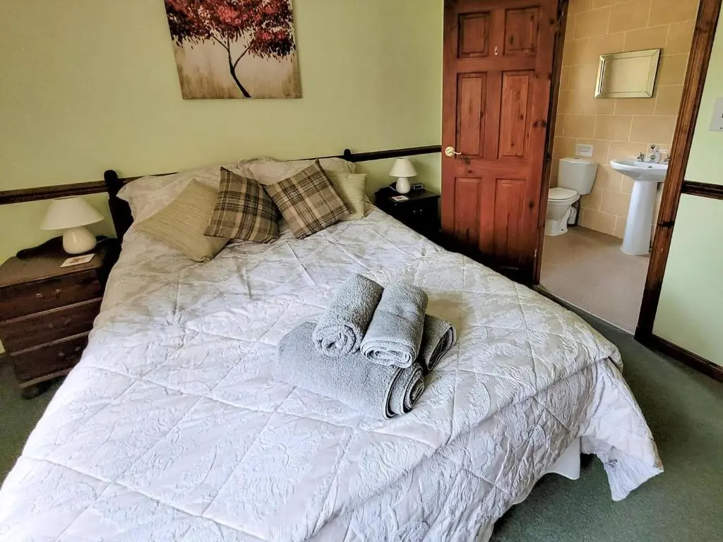 a bedroom with a bed with towels on it at The Birches in Ardclach