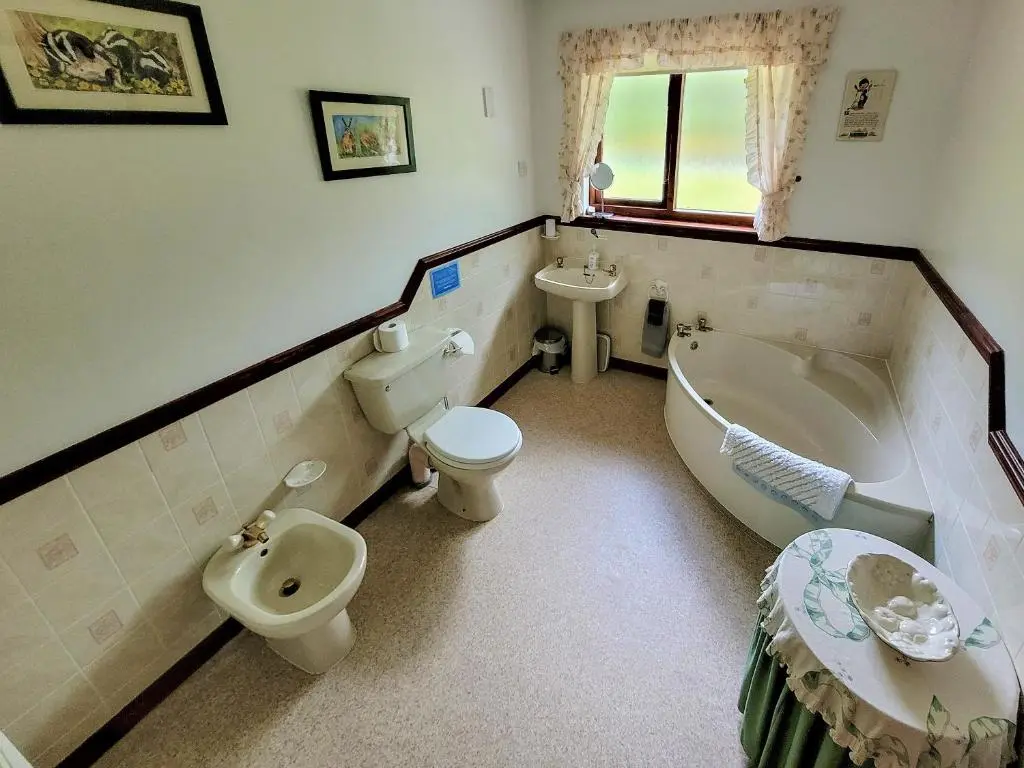 a bathroom with a tub and a toilet and a sink at The Birches in Ardclach