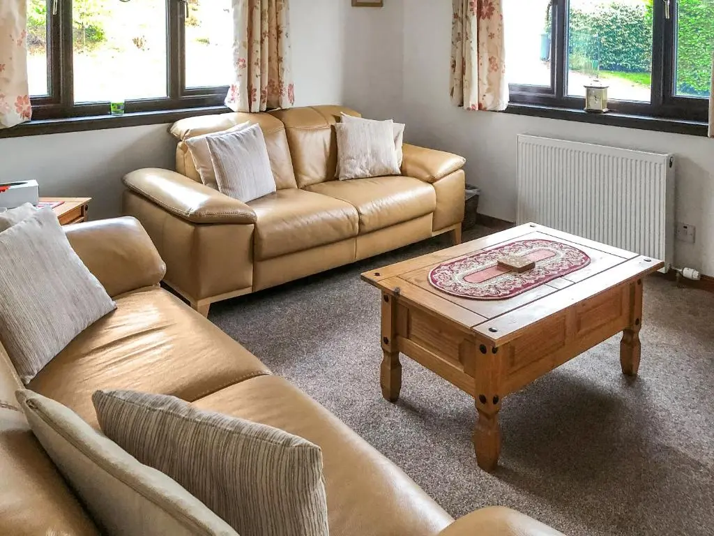 a living room with two couches and a coffee table at The Birches in Ardclach
