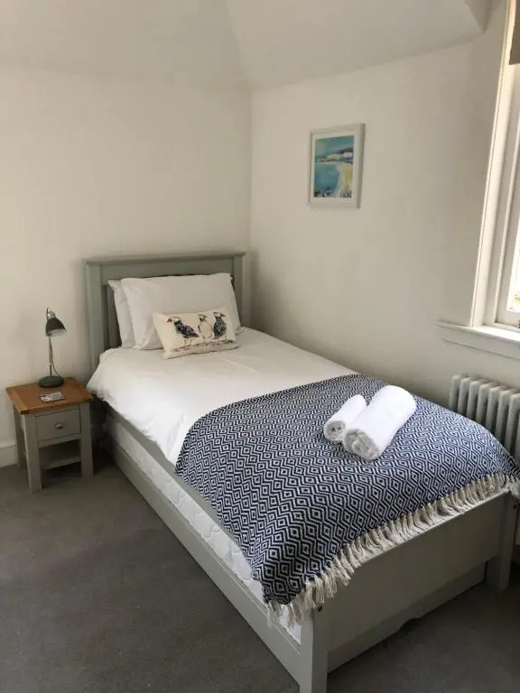 a small bedroom with a bed with a blue blanket at Fantastic central location in Inverness