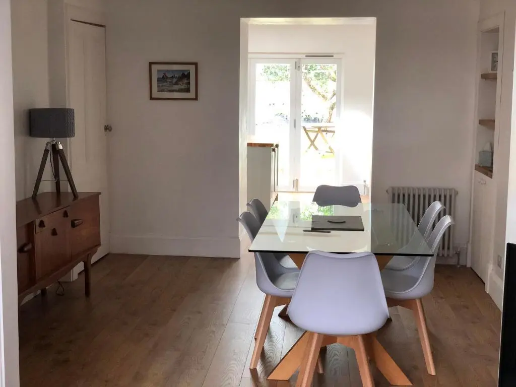 a dining room with a glass table and white chairs at Fantastic central location in Inverness