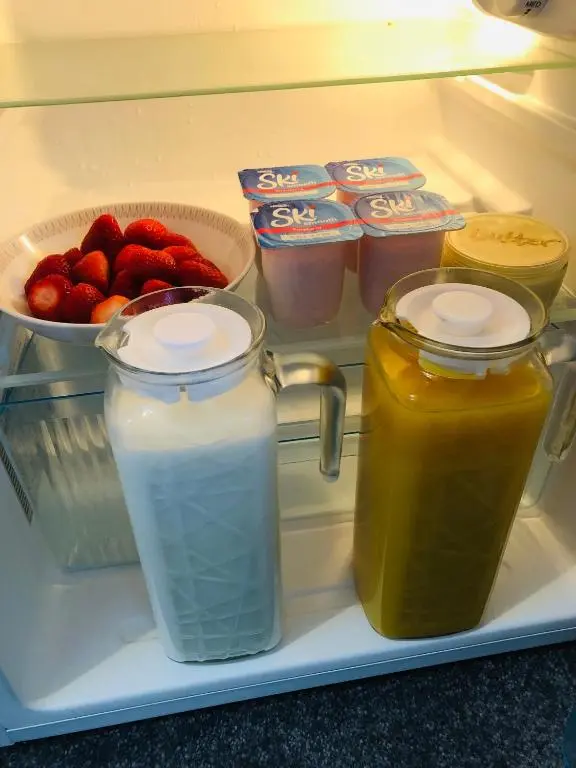 a refrigerator filled with drinks and a bowl of strawberries at Lettoch Farm in Dufftown