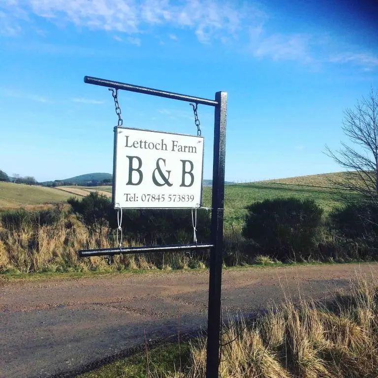 a sign for a tractor farm bd sign on the side of a road at Lettoch Farm in Dufftown