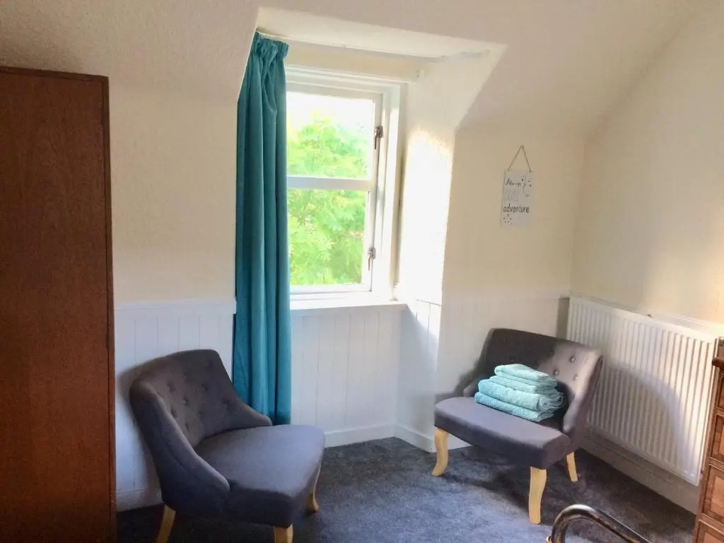 a living room with two chairs and a window at Lettoch Farm in Dufftown