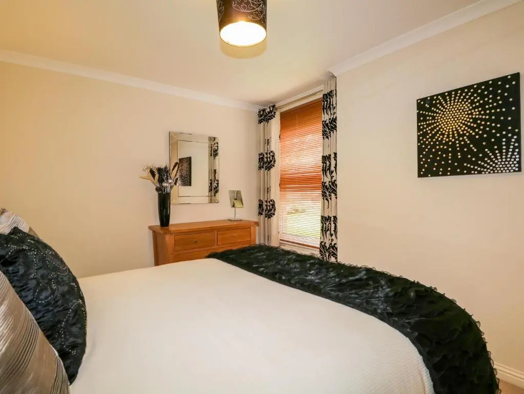 a bedroom with a white bed and a window at 7 Riverside Gardens in Inverness