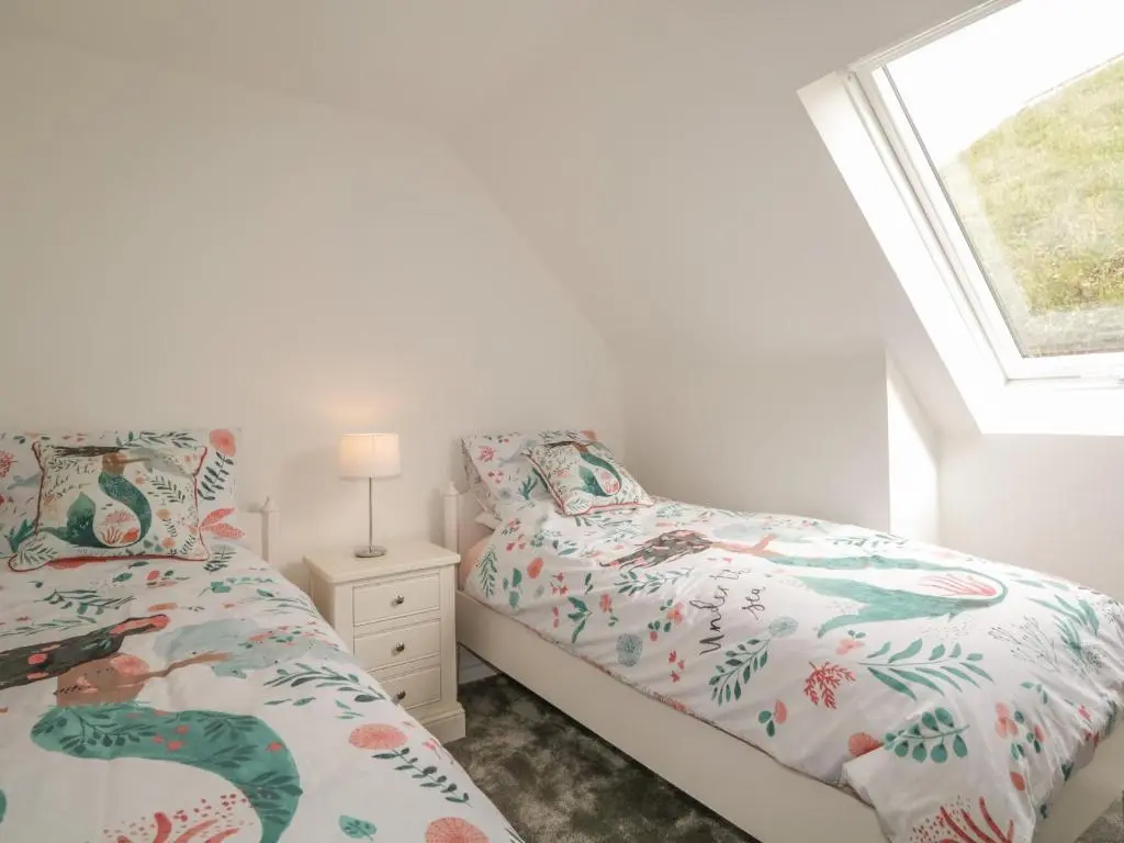 a bedroom with two beds and a window at 15 Waters Edge in Banff