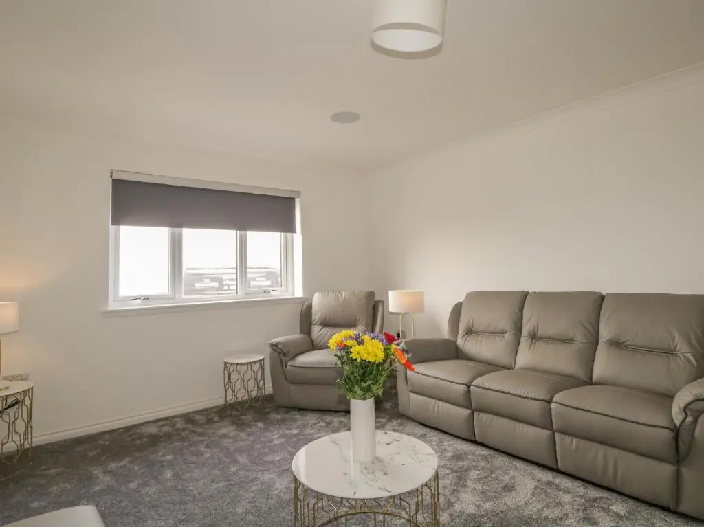 a living room with a couch and a table with flowers at 15 Waters Edge in Banff