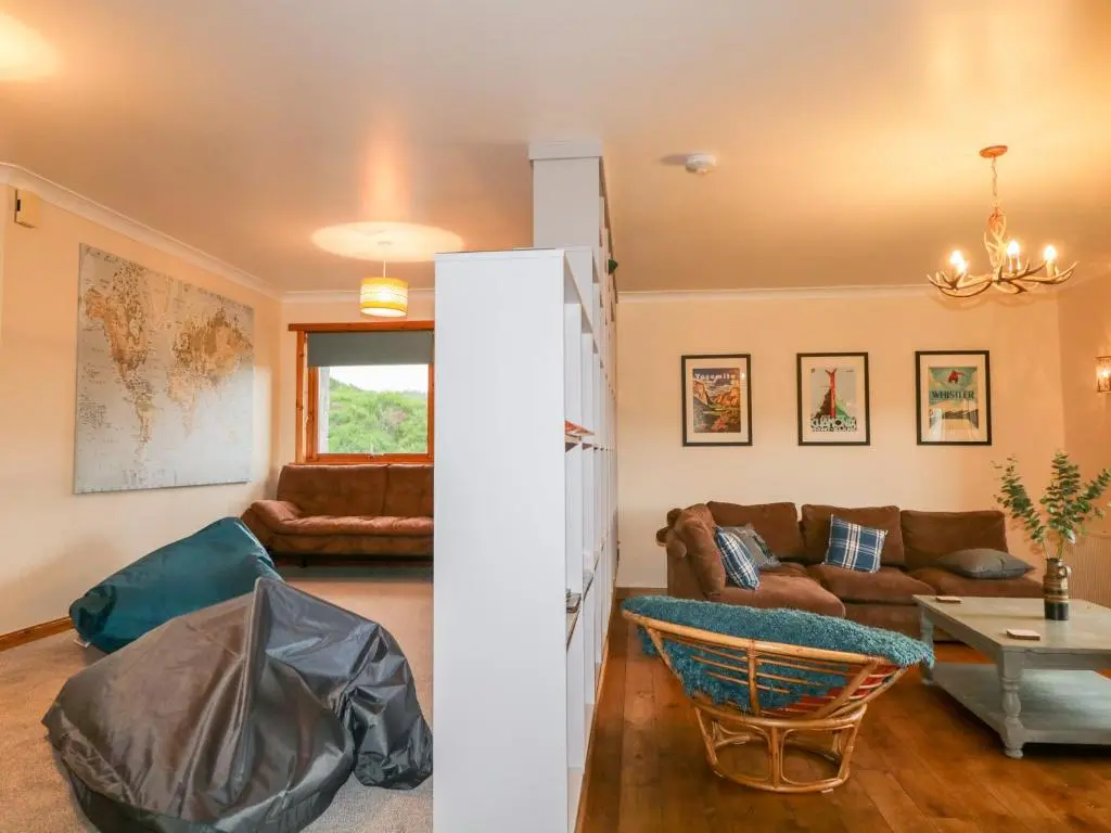a living room with a couch and a table at Ptarmigan in Carrbridge