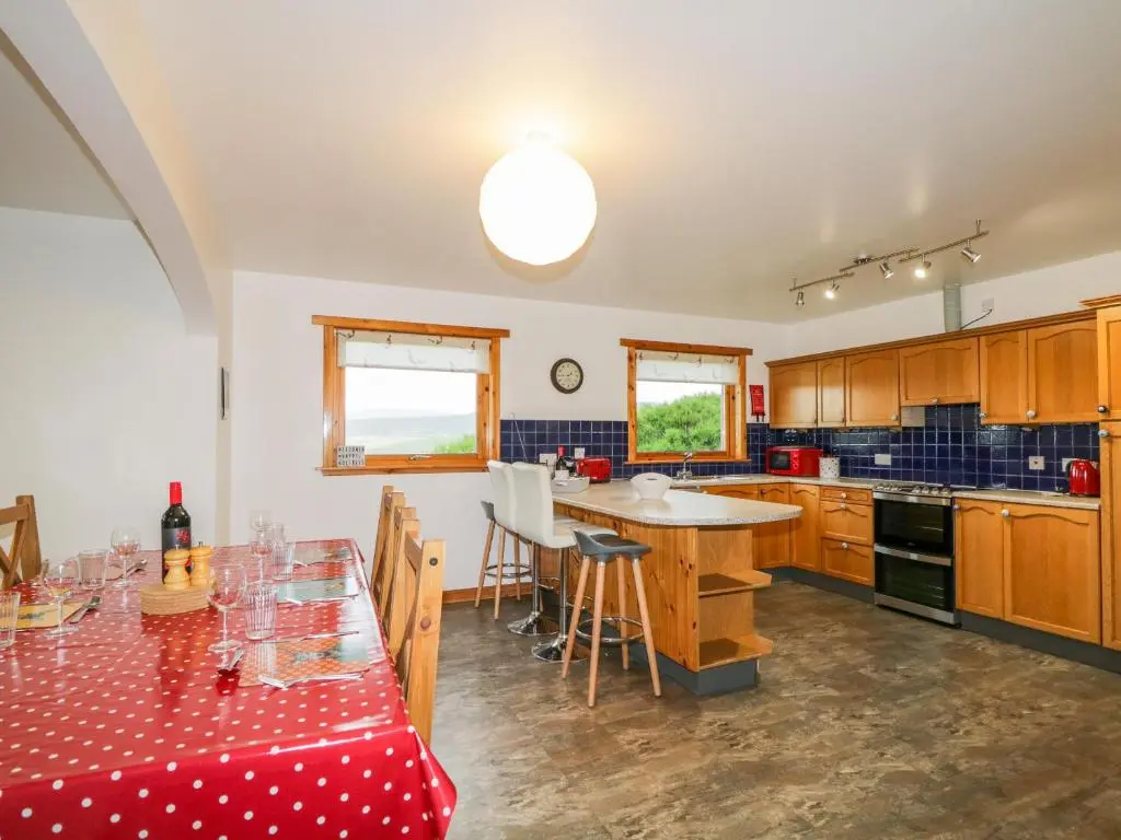 a kitchen with a table and a dining room at Ptarmigan in Carrbridge