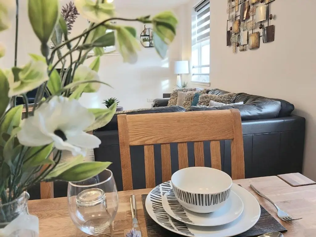 a dining room table with a bowl and plates on it at Inverness City Centre Apartment with Elevator and Google Chromecast in Inverness