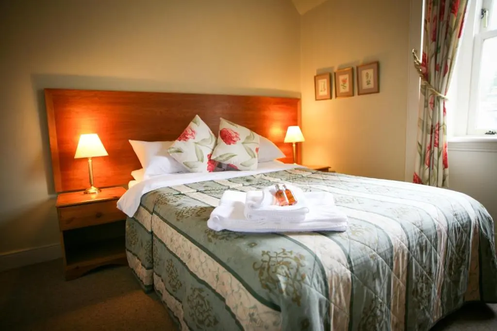 a hotel room with a bed with a tray on it at The Tomich Hotel in Tomich