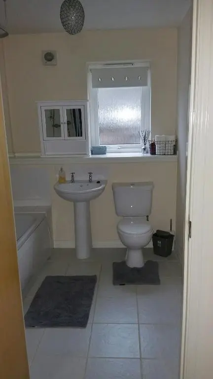 a bathroom with a toilet and a sink and a window at Lerwick Garden Apartment in Inverness