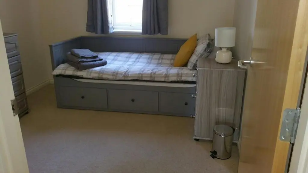 a small bedroom with a bed and a window at Lerwick Garden Apartment in Inverness