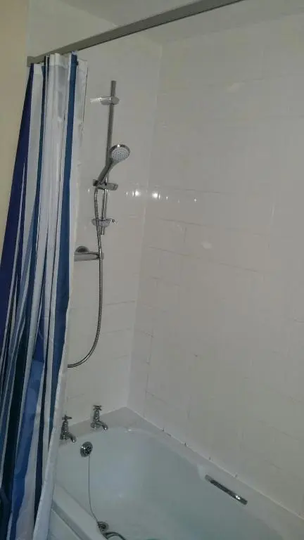 a bathroom with a bath tub with a shower at Lerwick Garden Apartment in Inverness