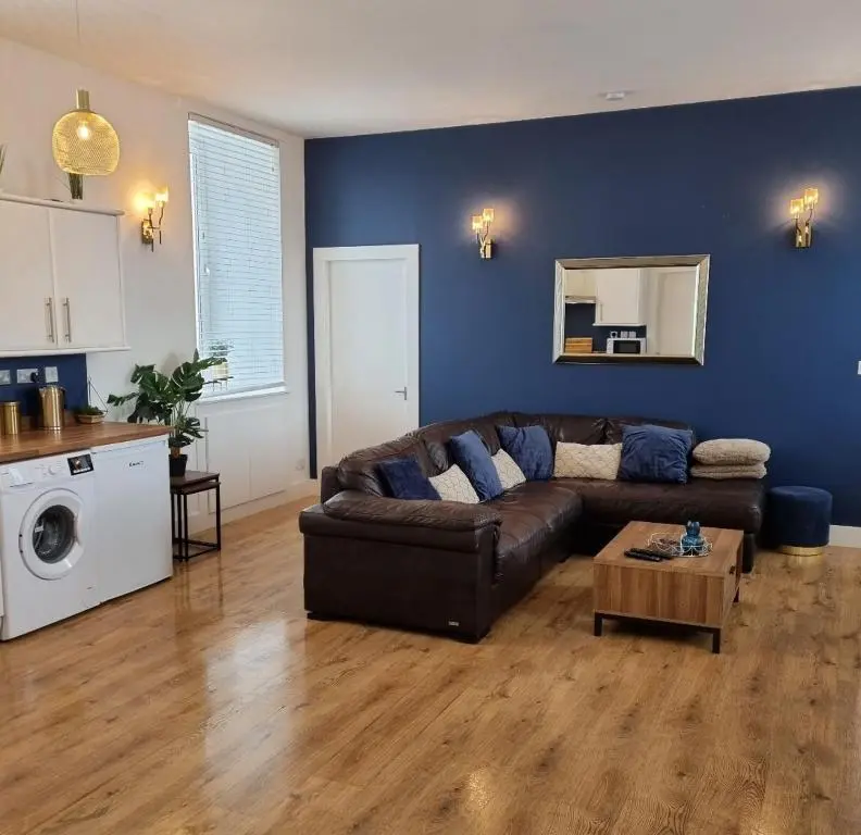 a living room with a brown couch and a table at City Centre Flat, Harbour View in Inverness