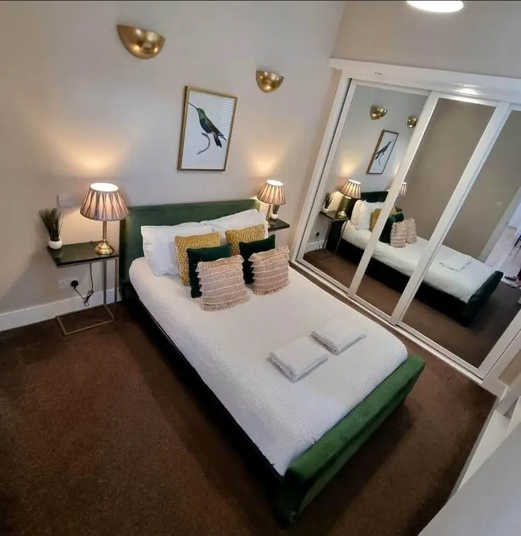 a bedroom with a large bed with pillows and a mirror at City Centre Flat, Harbour View in Inverness