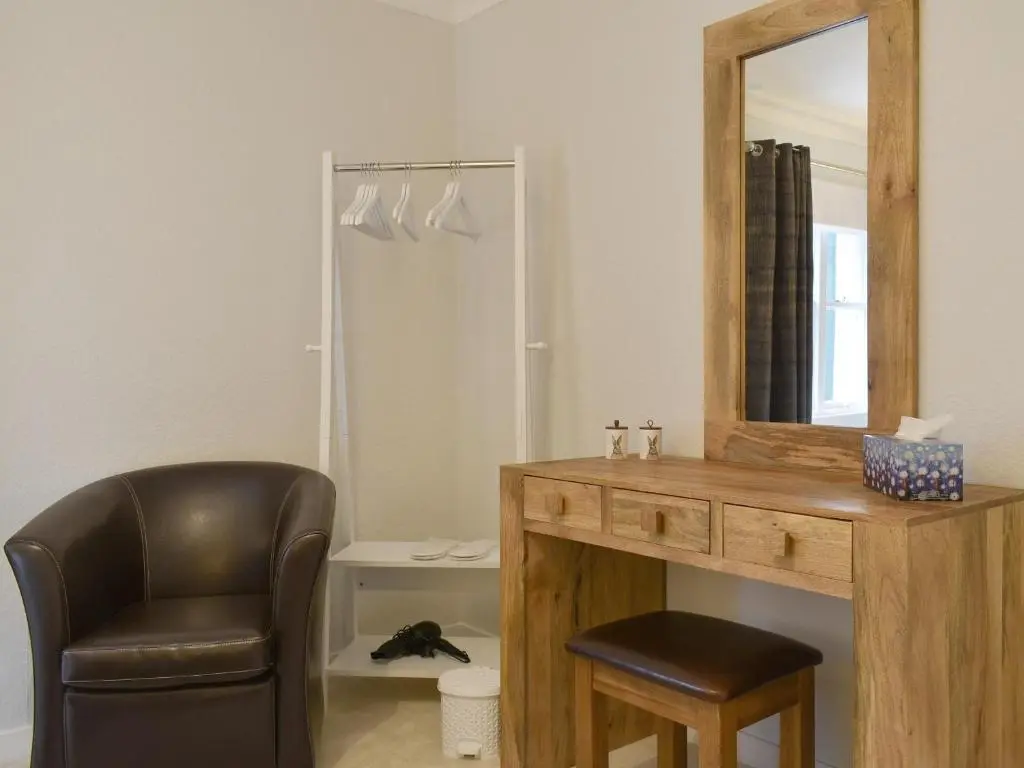a mirror and a chair in a room at West Lodge in Banchory
